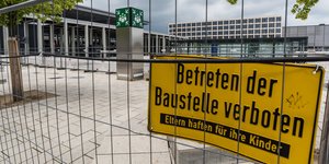 Baustellenzaun vor BER mit gelbem Schild: "Betreten der Baustelle verboten"