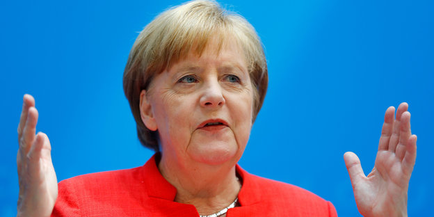 Angela Merkel hält dich Hände in einem Abstand auseinander