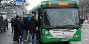 Menschen steigen in einen Bus ein