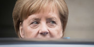 Merkel, die untere Gesichtshälfte verdeckt