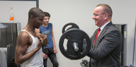 Boris Pistorius lässt sich von einem jungen Mann zeigen, wie man Gewichte hebt