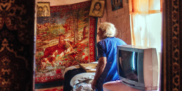 Eine ältere Frau steht im Schlafzimmer in einem Haus