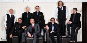 Acht Männer in Anzügen und mit Krawatte von der Band King Crimson