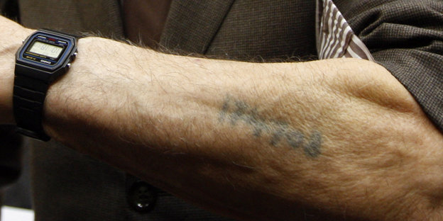 Ein Arm auf dem eine Nummer eintätowiert wurde von den Nazis. Er gehört einem ehemaligen Häftling des Konzentrationslagers Ausschwitz-Birkenau