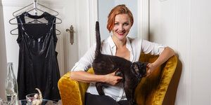 Kristina Marlen hält lächelnd eine Katze auf dem Schoß