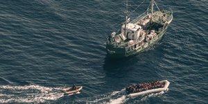Blick aus dem Suchflugzeug „Moonbird“ auf ein Rettungsschiff und ein Flüchtlingsboot