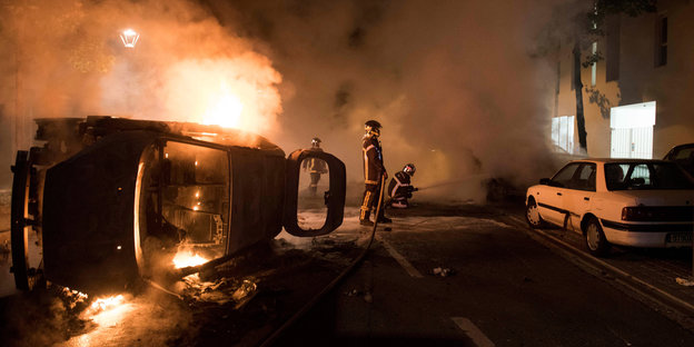 Nantes Ausschreitungen - ein Laster liegt Nachts brennend auf der Seite