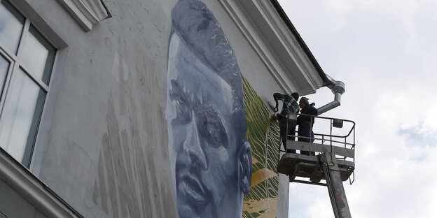 Künstler in Kasan verzieren eine Hausfassade mit dem Porträt des brasilianischen Nationalspielers Meymar