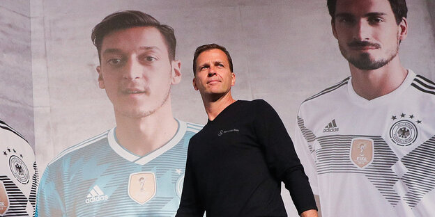 Team-Manager Oliver Bierhoff gehen an einem Poster mit den Spieler Mesut Özil und Mats Hummels vorbei.