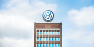 Hochhaus mit VW-Emblem, dahinter Himmel und Wolken