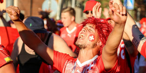 Ein Fußballfan der Schweiz jubelt vor Spielbeginn.