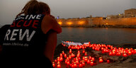 Ein Crew-Mitglied der Lifeline mit Gedenkkerzen am Strand von Malta