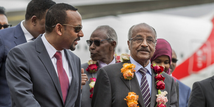 Osman Sale und Abiy Ahmed laufen vor einem Flugzeug