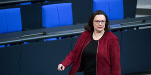 Andrea Nahles steht vor leeren Sitzen im Bundestag