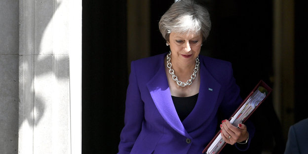 Premierministerin Theresa May hält eine Mappe in der Hand