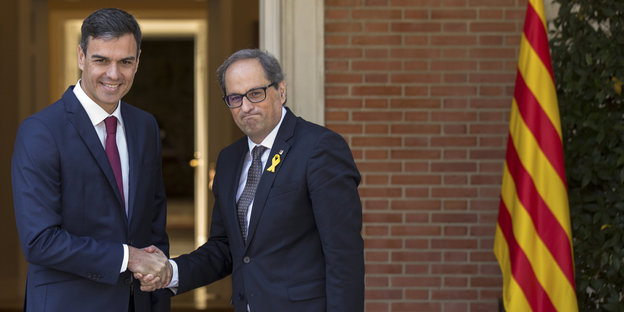 Ministerpräsident Sánchez schüttelt Kataloniens Regionalpräsidenten Quim Torra die Hand.