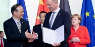 Bundeskanzlerin Angela Merkel und Chinas Ministerpräsident Li Keqiang stehenhinter Wolfgang Tiefensee, Wirtschaftsminister von Thüringen, und Zeng Yuqun, Geschäftsführer von Contemporary Amperes Technology
