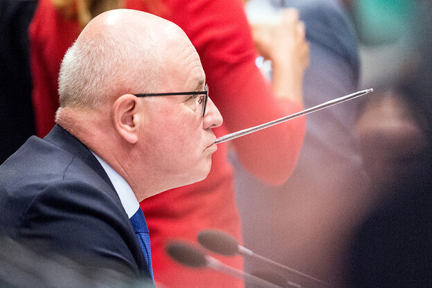Profilaufnahme des CDU-Politikers Volker Kauder. Aus seinem Mund ragt ein verpackter Trinkhalm schräg nach oben.