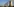 Drei Reaktoren eines AKWs vor einem blauen Himmel; es steigt Rauch auf