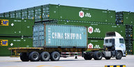 Ein Lastwagen mit der Aufschrift "China Shipping" steht vor befüllten Containern