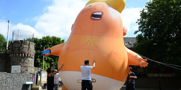 Ein überlebensgroßer Ballon, der US-Präsident Trump als Baby darstellt, wird im Bingfield Park in London aufgepumpt.
