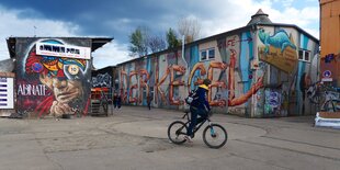 Ein Radfahrer vor einer bunt bemalten Wand