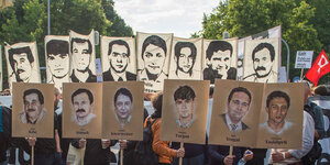 Menschen auf einer Demonstration nach dem Urteil im NSU-Prozess. Sie halten Plakate mit den Bildern der Getöteten in die Höhe