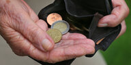 Rente in Deutschland: Die Hände einer älteren Person halten eine Geldbörse