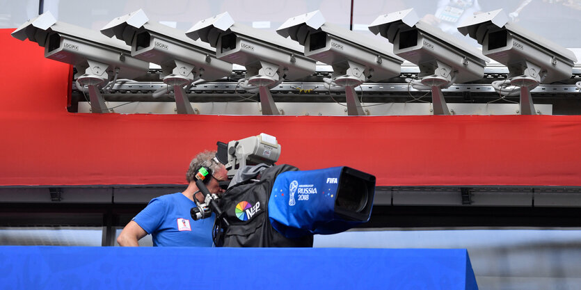 Ein TV-Kameramann filmt im Stadion unter Überwachungskameras