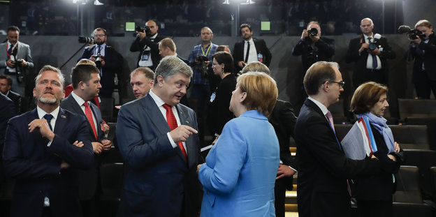 Petro Poroschenko, Präsident der Ukraine, und Bundeskanzlerin Angela Merkel (CDU, r) unterhalten sich zu Beginn der Arbeitssitzung des Nordatlantikrates beim Nato-Gipfel.