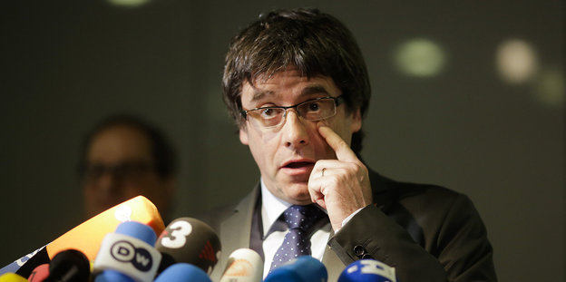 Carles Puigdemont gibt ein Pressestatement und fasst sich ans Auge
