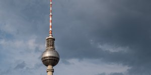 Der Fernsehturm in Berlin und ein Stück Himmel mit einer großen Wolke