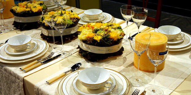 Ein gedeckter Tisch mit vielen Tellern und Torten