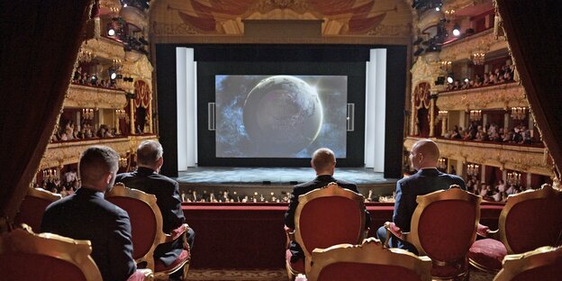 Wladimir Putin und Gianni Infantino sitzen in freudiger Erwartung in einem Kino und erwarten das WM-Abschlusskonzert.