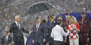 Putin unter einem Schirm, es regnet in Strömen