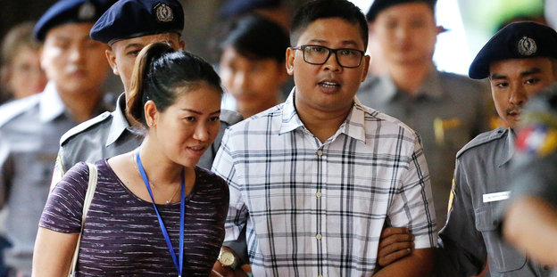 Der inhaftierte Reuters-Journalist Wa Lone läuft mit seiner Frau Pen Ei Mon in Polizeibegleitung zum Gericht