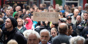 Eine Frau hält auf einer Demonstration unter dem Motto "Fünf Jahre NSU-Prozess - Kein Schlussstrich" ein Schild mit der Aufschrift "Kein Schlussstrich - Rassismus tötet" in die Höhe