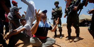 Proteste von Palästinensern gegen jüdische Siedlungen im vergangenen Juni in der Nähe von Hebron. Drum herum stehen israelische Soldaten