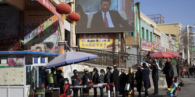 Bewohner laufen durch einen Sicherheitscheck in der Provinz Xinjiang