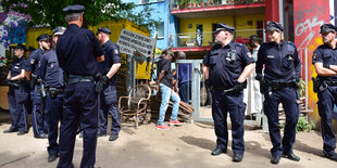 Polizisten stehen vor einem bunt angemalten Haus.