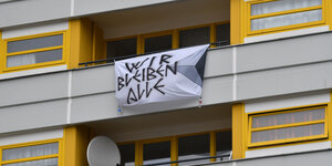 Wohnungsbalkon mit Transparent "Wir bleiben alle"