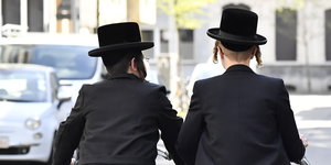Orthodoxe jüdische Jungen fahren im Jüdischen Viertel in Antwerpen auf ihren Fahrrädern