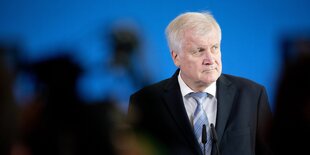 Ein Mann steht vor Kameras und guckt ernst. Es ist Horst Seehofer