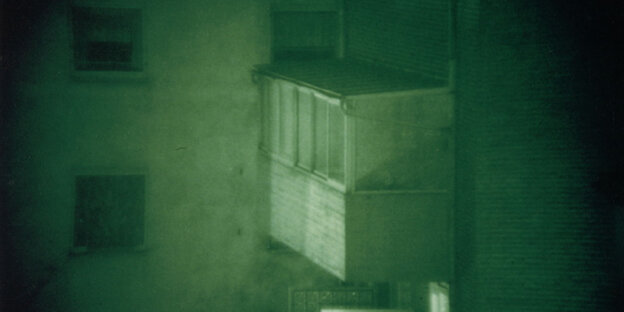 Ein Hinterhof in der schwarz-grünlichen Aufnahme einer Nachtsichtkamera.