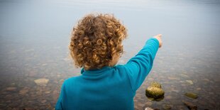 Symbolbild: Ein Kind zeigt in die Landschaft