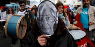Ein Demonstrant mit einer Maske von Christine Lagarde