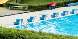 Ein leeres Freibad, am Beckenrand stehen Sprungtürme