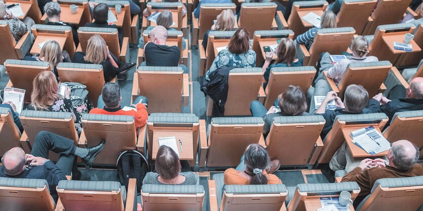 Menschen sitzen in einem Hörsaal