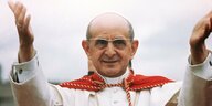 Ein Mann mit Umhang hebt die Arme in die Höhe. Es ist Papst Paul VI.