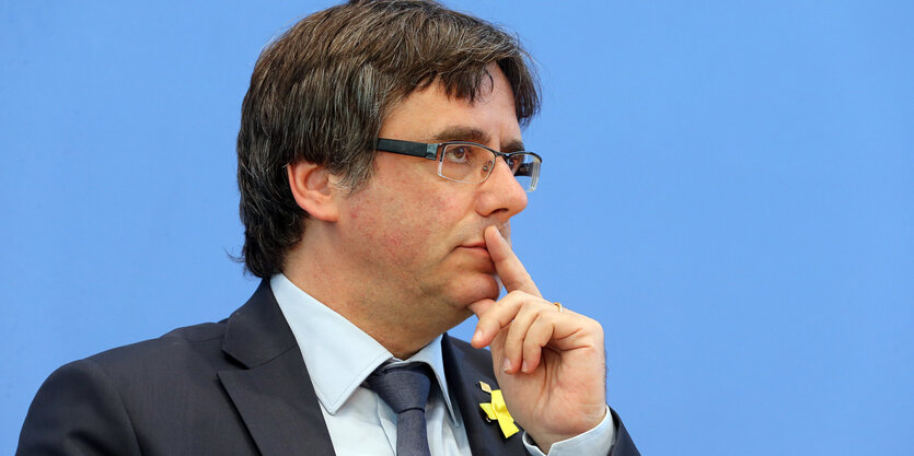 Carles Puigdemont hält sich den Zeigefinger vor den Mund